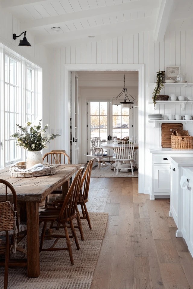 Minimalist white kitchen adjacent to colorful eclectic dining