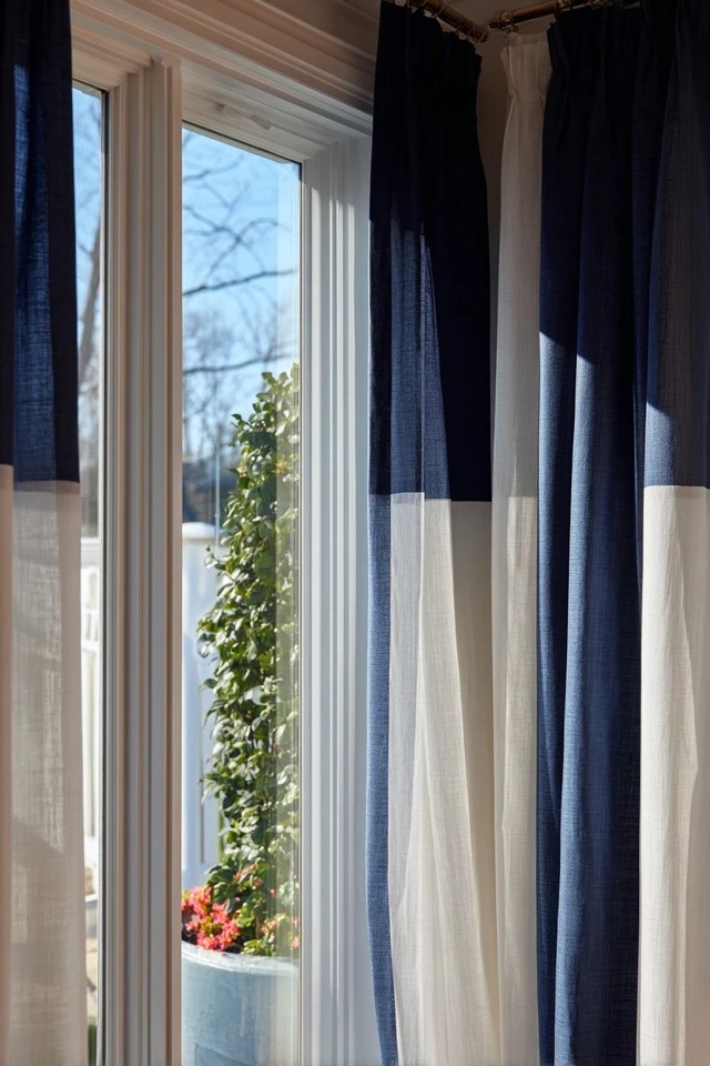 Two-tone colour-block curtain panels creating bold modern graphic window statement in a contemporary sunroom