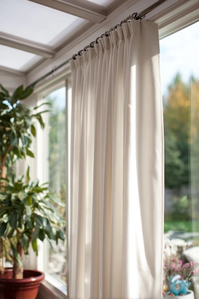 Thermal-backed curtain panels providing insulating climate control in a year-round sunroom
