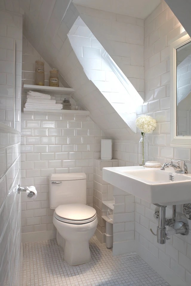 White subway tiles in running bond pattern creating a bright fresh classic surface in a small attic bathroom