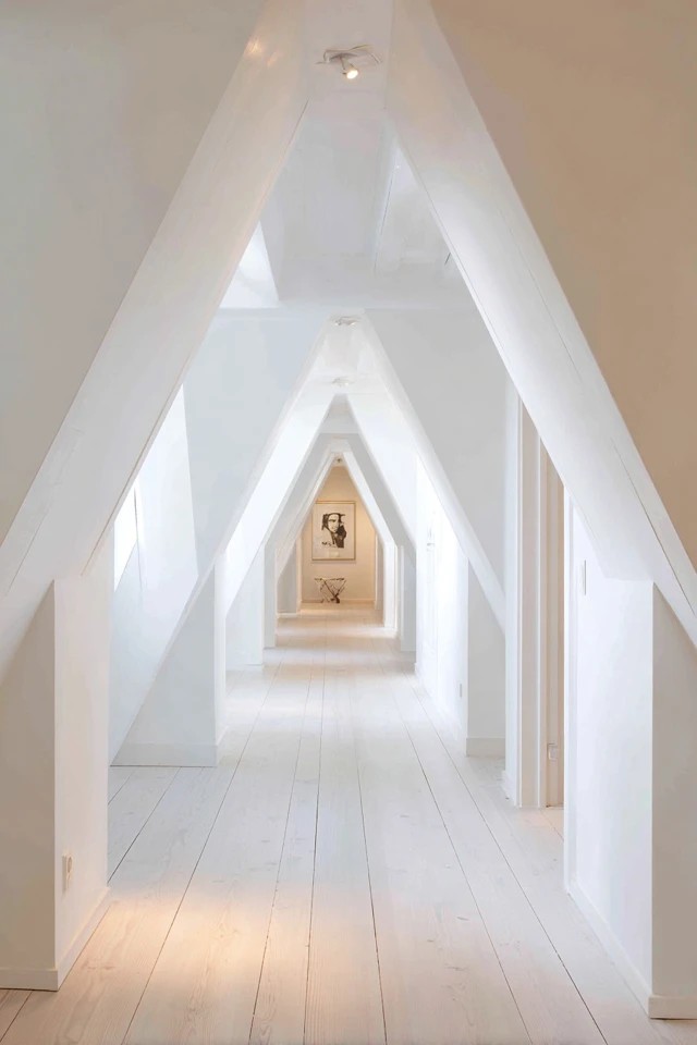 White painted walls, ceiling, and trim creating a bright airy expansive feeling in a compact attic apartment