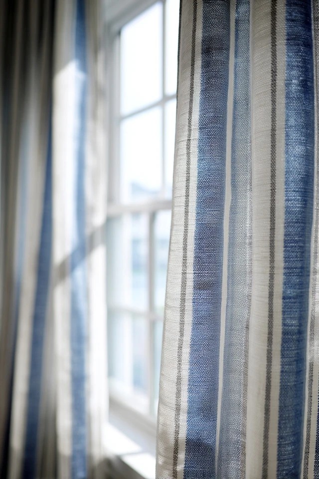 Leaf and floral botanical print curtain panels creating decorative garden-inspired window accent in a sunroom