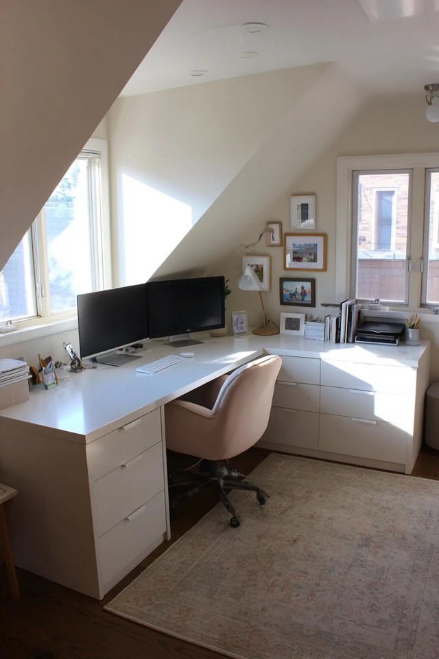 Height-adjustable sit-stand desk in an attic office allowing alternating seated and standing work positions