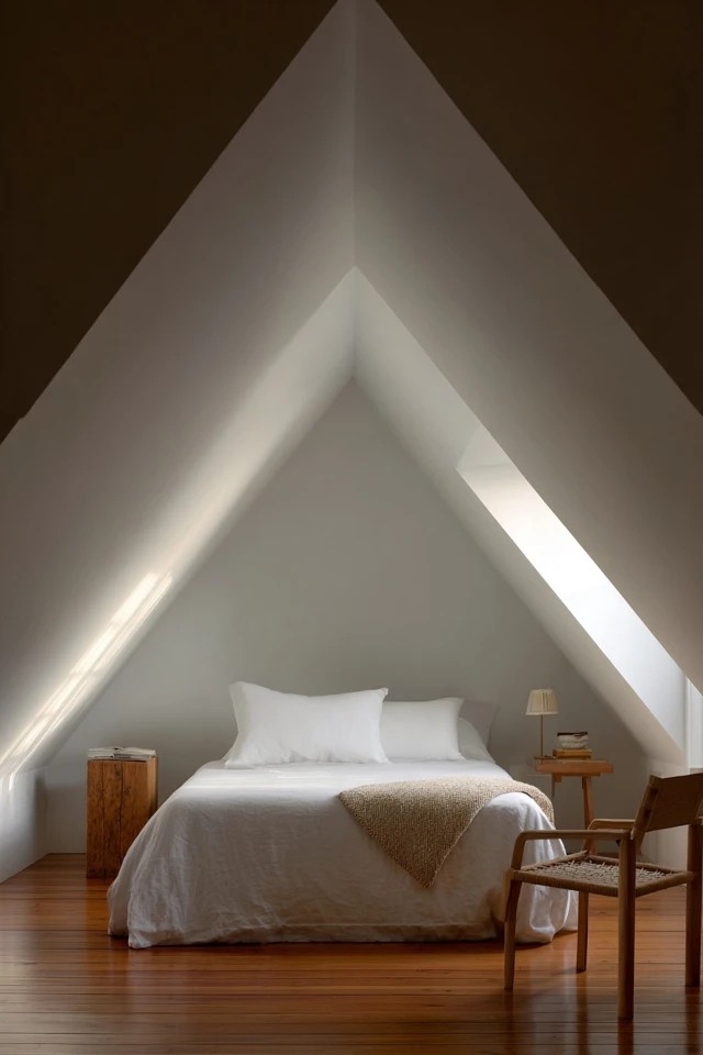 Cushioned built-in reading bench nestled under the attic eave creating a cosy retreat corner in a bedroom