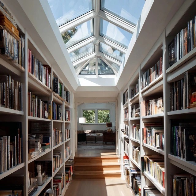 Skylight installed in the attic library ceiling flooding bookshelves and reading areas with natural overhead daylight